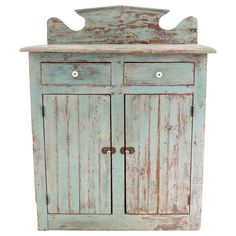 an old blue wooden cabinet with two doors and one drawer on the front, against a white background