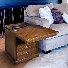 a living room with a couch, coffee table and bar stools next to it