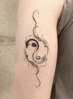 a woman's arm with a black and white tattoo design on the left forearm