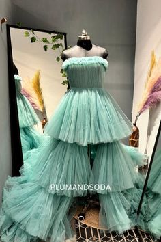 a dress made out of tulle and feathers on display in front of a mirror