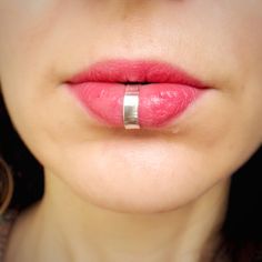 a close up of a woman's lips with a ring on her lip