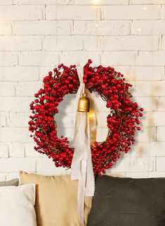 a christmas wreath hanging on the wall next to pillows