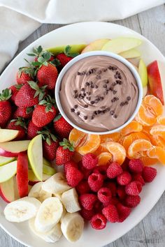 a white plate topped with fruit and chocolate dip