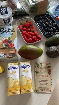 fruit, yogurt, and other foods are laid out on a counter top