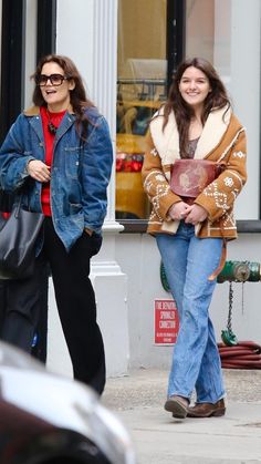 two women are walking down the street together