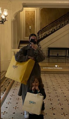 a woman taking a selfie with her child while holding shopping bags in front of her