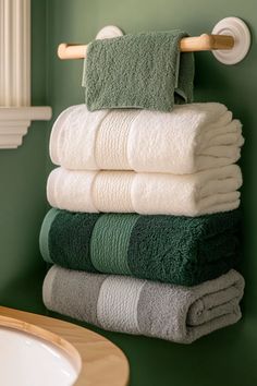 Light sage green bathroom with coordinating towels on wooden rack sage green bathroom cabinets visible