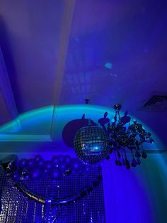 a room with blue lights and balloons on the ceiling, as well as a chandelier