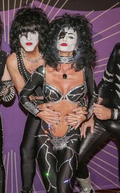 three women dressed in black and white makeup posing for the camera with their hands on their hips