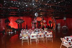 a party hall with tables and chairs set up for an event or function, decorated in black and red