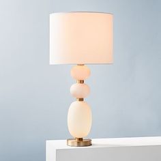 a table lamp sitting on top of a white shelf next to a blue wall and floor