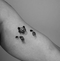 a black and white photo of someone's foot with a panda bear tattoo on it