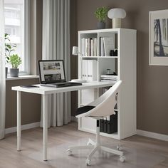 a desk with a laptop on it in front of a bookcase filled with books