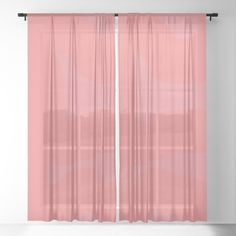 a pink curtain hanging in front of a white wall