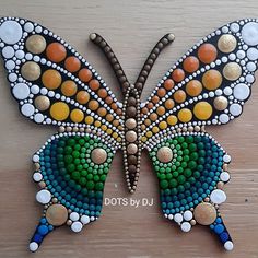 a painted butterfly sitting on top of a wooden table