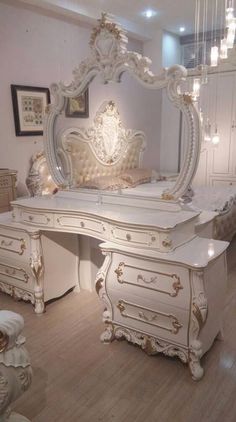 an ornate white dresser and mirror in a room