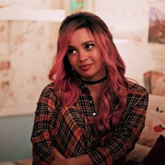 a woman with pink hair is posing for the camera