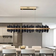 a modern dining room with white chairs and black chandelier hanging from the ceiling