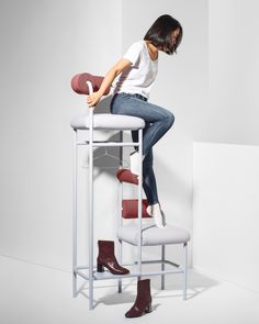 a woman sitting on top of a white chair