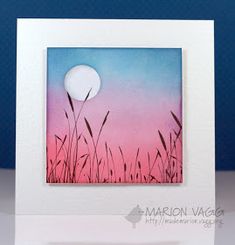 a card with the image of grass in front of a pink and blue sky at sunset