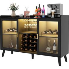 a black cabinet with wine bottles and glasses on the top shelf is filled with liquor