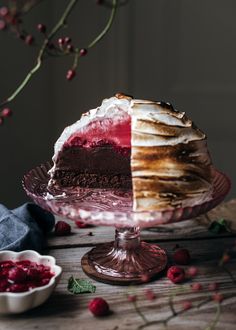 a piece of cake on a plate with raspberry sauce