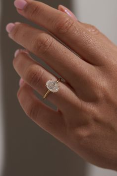 a woman's hand with a diamond ring on it