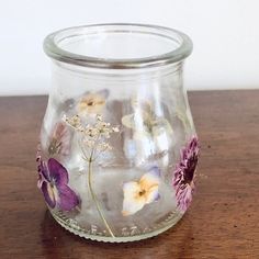 a glass vase with flowers painted on it