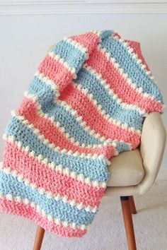 a crocheted blanket sitting on top of a chair