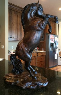 a statue of a horse on its hind legs in a kitchen with granite counter tops