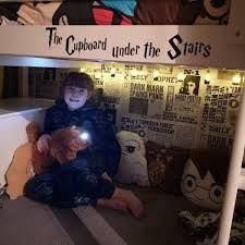 a person sitting on the floor under a bunk bed with stuffed animals and lights in front of them