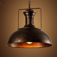 an old fashioned light hanging from a ceiling fixture with a brown wall in the background