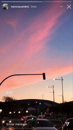 an image of a street light and cars at dusk with the sky in the background