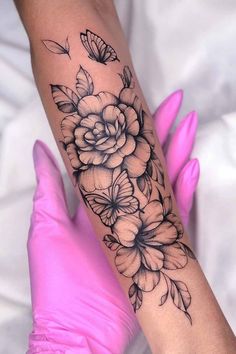 a woman's arm with flowers and butterflies on it