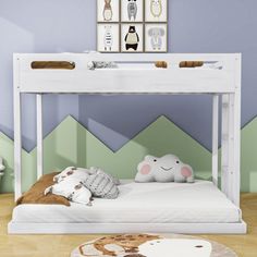 a white bunk bed sitting in a bedroom next to a wall with pictures on it