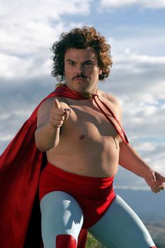 a man in a red and white costume is posing for the camera with his cape around his neck