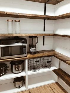 a microwave, toaster and coffee maker are on shelves in a small kitchen area