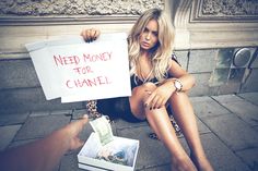 a woman sitting on the ground holding a sign that says need money for chanel