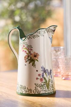 a white pitcher sitting on top of a wooden table