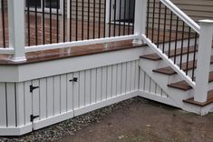 a wooden deck with white railing and handrails