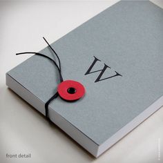 a book with a red button attached to it