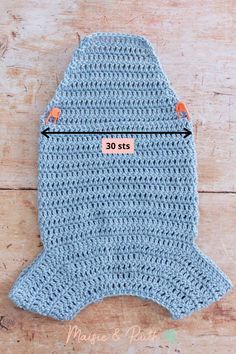 a crocheted blue dog sweater with an orange tag on the front and bottom