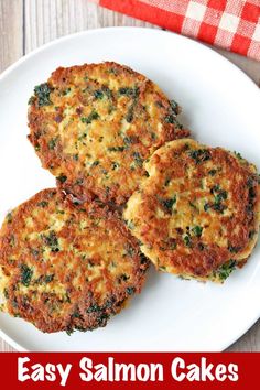 three crab cakes on a white plate next to a red and white checkered napkin