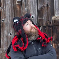 a bearded man wearing a knitted hat with an octopus on it's side