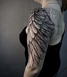 a woman with black and grey wings on her arm