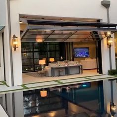 an open living room and dining area are reflected in the pool