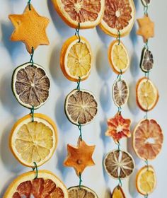 orange slices and star shaped cookies hanging from strings on a white wall with green string