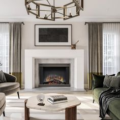 a living room with couches, chairs and a fire place in the middle of it