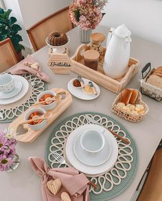 the table is set with plates, cups, and other items for breakfast or brunch