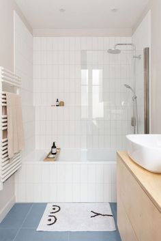 a bathroom with a sink, bathtub and towel rack